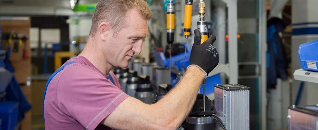 Mitarbeiter in der Montage mit einem Schrauber an einem Antrieb