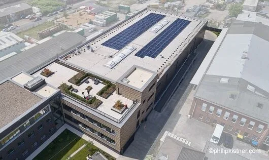 Luftbild des Flachdachs mit Photovoltaik-Anlage und begrünter Dachterrasse