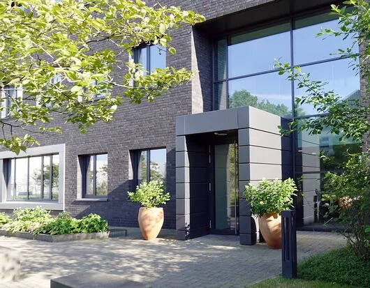 Eingang des Verwaltungsgebäudes mit Klinkerfassade und Pflanzkübeln